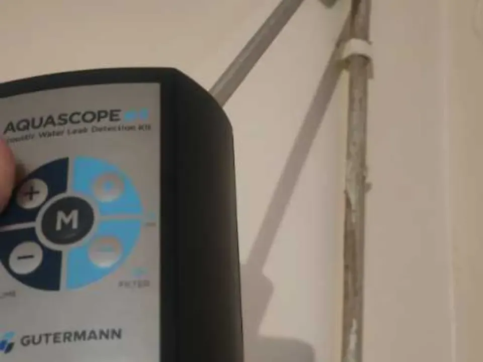 Acoustic listening device held against pipework at basement stopcock during leak detection