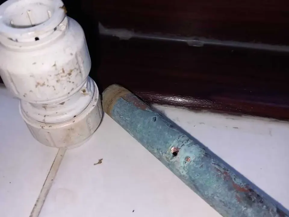 Fault identified at corroded copper pipe with push-fit connector removed showing pinhole damage