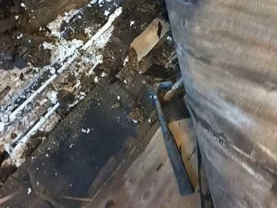 Leak exposed beneath kitchen floor showing saturated rotted subfloor timbers and standing water