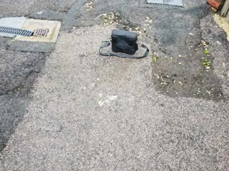 Acoustic listening device placed on courtyard tarmac patch during leak detection
