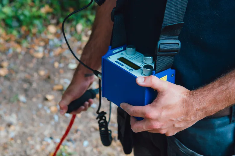 Engineer outdoors with acoustic leak detection equipment