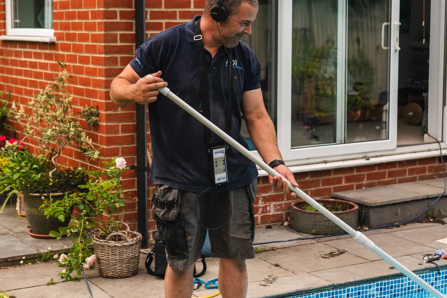 Engineer using acoustic equipment to trace a swimming pool leak